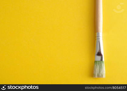 A paintbrush isolated on a yellow background