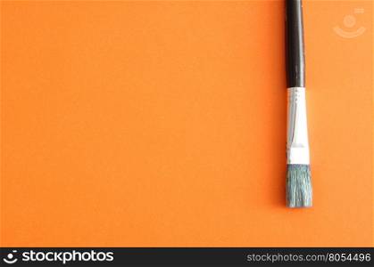 A paintbrush isolated on an orange background