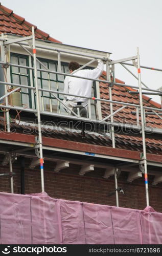 A painter working on a covered scaffolding