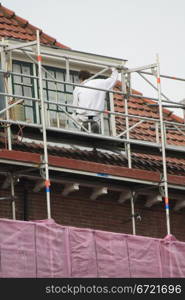 A painter working on a covered scaffolding