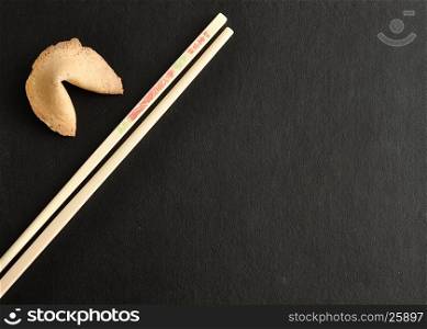 A pair of chopsticks with a fortune cookie