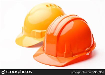 A pair of hard hats, yellow and orange, isolated on a white background. Hard hats