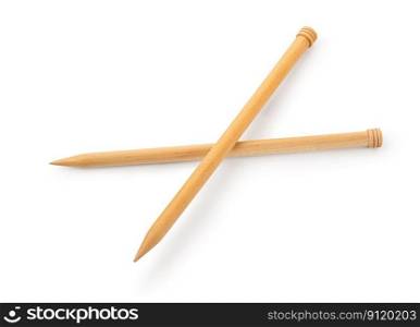 A pair of large wooden knitting needles from low perspective isolated against white background.