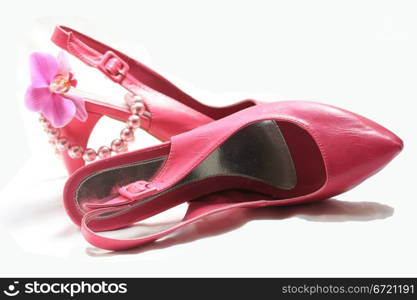 A pair of pink leather ladies shoes, an orchid and a pearl necklace, fashionista accessories