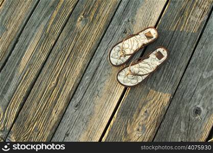 A pair of sandals on a boardwalk