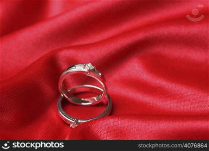 A pair of wedding rings on a red cloth