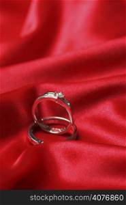 A pair of wedding rings on a red fabric