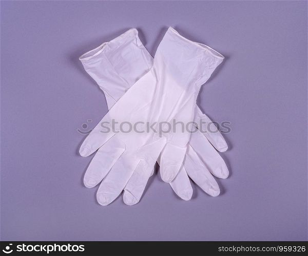 A pair of white medical gloves on a gray background