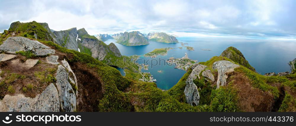 A panoramic view from the top of a cliff, overlooking small island towns connected by bridges. Shot above the arctic circle on Lofoten Island, Norway