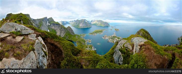 A panoramic view from the top of a cliff, overlooking small island towns connected by bridges. Shot above the arctic circle on Lofoten Island, Norway