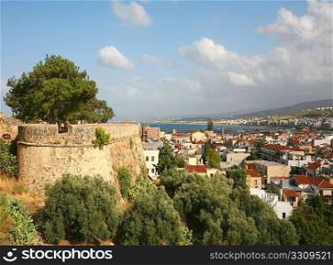 A panoramic view of Rethymnon city on Crete, Greece, with part of the Fortezza castle wall on the left.