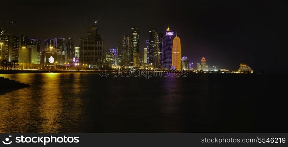 A panoramic view of the skyline of Doha, Qatar, at night.
