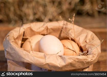 a paper bag filled with raw chicken eggs