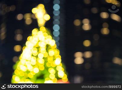 A part of christmas tree colorful bokeh with urban city lighting background.