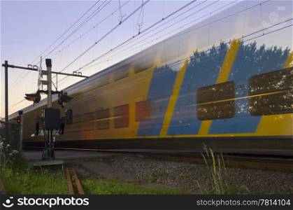 A passing train at full speed during sunset