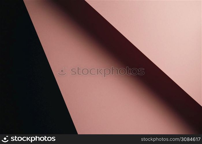 A pastel pink and black flat lay background with sharp layers and shadows with copy space