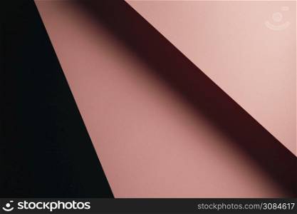 A pastel pink and black flat lay background with sharp layers and shadows with copy space