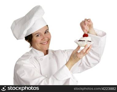 A pastry chef putting a strawberry on the top of a cheesecake tart. Isolated on white.