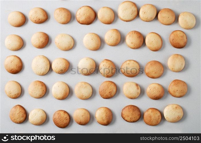 A pattern of a small pancakes. Background from orange toasted round biscuits. home bakery. A pattern of small pancakes. Background from orange toasted round biscuits. home bakery