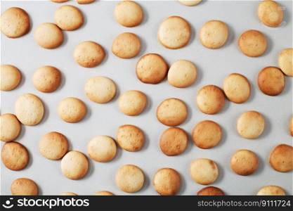 A pattern of a small pancakes. Background from orange toasted round biscuits. home bakery. A pattern of small pancakes. Background from orange toasted round biscuits. home bakery