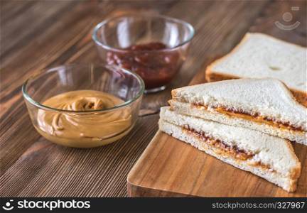 A peanut butter and jelly sandwich on the wooden board