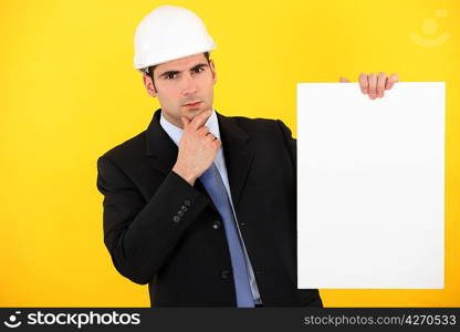 A pensive architect holding a poster.