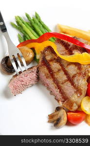 A perfectly cooked veal sirloin steak sliced open and served with mushrooms, capsicum ribbons, asparagus fries.