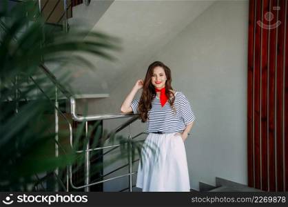 A perky girl in a striped T-shirt with a red tie.. A photo shoot of an adult girl in a pioneer tie 4167.