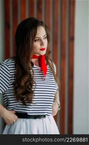 A perky girl in a striped T-shirt with a red tie.. A photo shoot of an adult girl in a pioneer tie 4170.