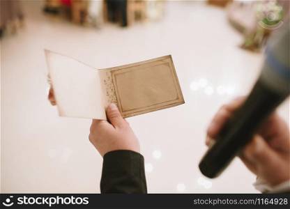 A person holds a greeting card and reads it close up. A person holds a greeting card and reads it.
