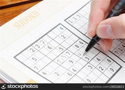 A person solving a sudoku puzzle