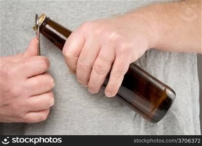A person using a bottle opener to open a beer.