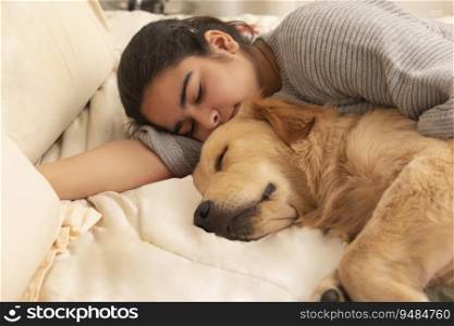 A PET DOG AND TEENAGER SLEEPING TOGETHER ON BED