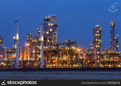 A petrochemical plant, with it&rsquo;s stainless steel cylinders, it&rsquo;s valves, chimneys, pipes, tubes and construction artificially lit just before the break of dawn
