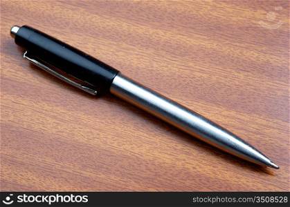 a photo of a pen a over wood background