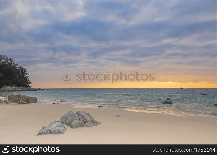 A photo of a sunset landscape where the sea is reflected in the orange light and the blue water is refreshing. At Bang Tao Beach, Phuket Province, Thailand. Concept about travel, nature. No people.
