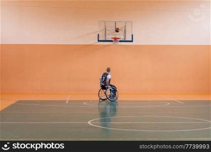 a photo of a war veteran playing basketball in a modern sports arena. The concept of sport for people with disabilities. High quality photo. Selective focus . a photo of a war veteran playing basketball in a modern sports arena. The concept of sport for people with disabilities