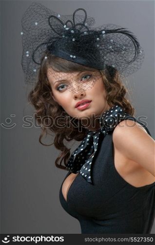 A photo of puzzled beauty in the web hat.