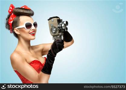 A photo of the pin-up girl in corset and gloves holding vintage 8mm camera.