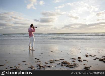 A photographer taking a photo on the beach.