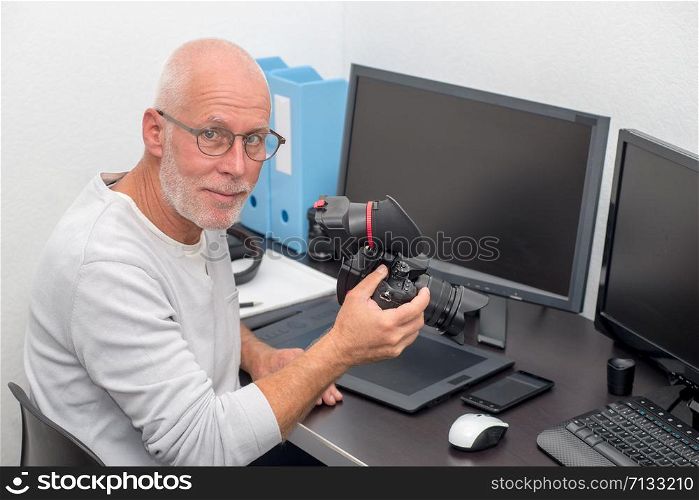 a photographer with camera at office with computer