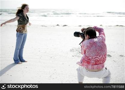 A photographer working with a model to get the right pose. Shallow depth of field with focus on photographer&rsquo;s head.