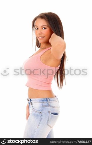 A picture of a young pretty woman standing in jeans and a pinktop, with one hand behind her head, isolated on white background.