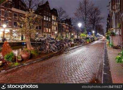 A picturesque view of the city embankment and facades of medieval fairy houses at sunset. Amsterdam. Netherlands.. Beautiful old houses on the city waterfront of Amsterdam at sunset.