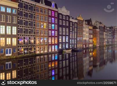 A picturesque view of the city embankment and the facades of old dancing houses at dawn. Amsterdam. Netherlands.. Famous dancing houses on the Amsterdam city waterfront at dawn.