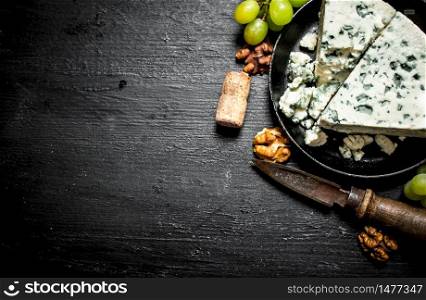 A piece of blue cheese, walnuts and white grapes.. piece of blue cheese, walnuts and white grapes.
