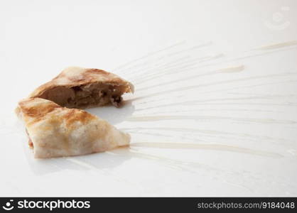 a piece of cake poured with sweet sauce over white background. cake on a white background