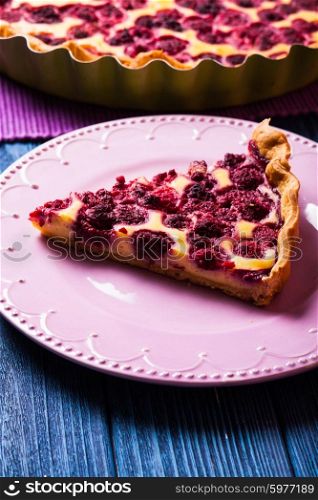 A piece of cheesecake with raspberries on a plate. Cheesecake with raspberries