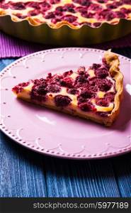 A piece of cheesecake with raspberries on a plate. Cheesecake with raspberries