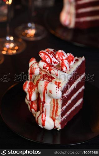 A piece of creepy cake (red velvet), decorated with meringue bones and drenched in blood. Great idea than treating guests. Close-up.